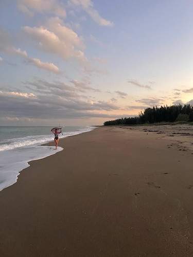 Woman walking through wave on beach