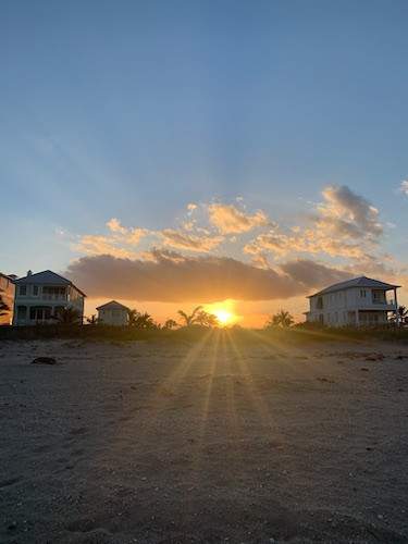 Sun rising between two homes